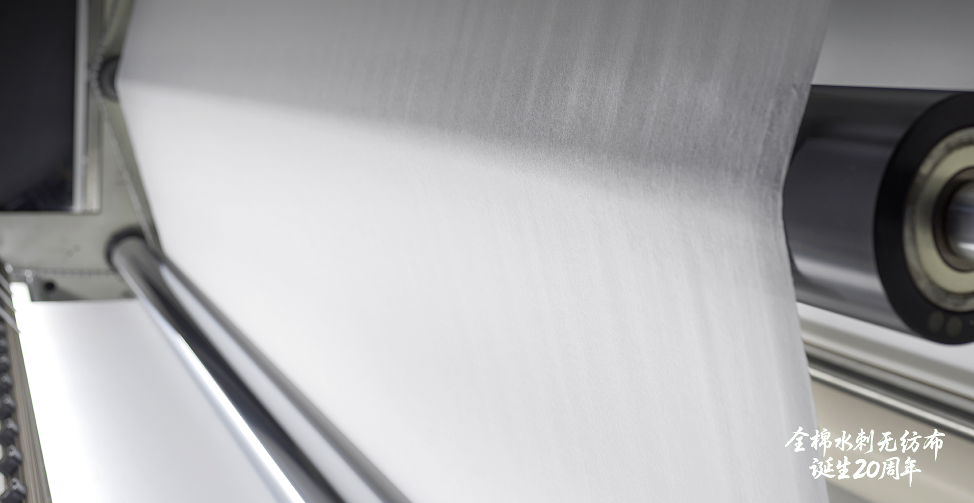 Close-up view of all-cotton spunlace fabric rolling off the production line